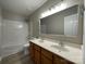 Well-lit bathroom with a double sink vanity, large mirror, and shower-tub combo at 107 Ameena Chase Trl, Mooresville, NC 28117