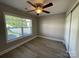 Bedroom features a ceiling fan, large window, and a closet with bi-fold doors at 107 Ameena Chase Trl, Mooresville, NC 28117