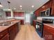 Well-lit kitchen features stainless steel appliances and cherry-stained cabinetry at 107 Ameena Chase Trl, Mooresville, NC 28117