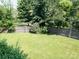 A well-kept, grassy backyard, enclosed by a wooden fence and mature trees at 11911 Brownestone View Dr, Charlotte, NC 28269