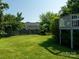Large backyard with a wooden fence and green lawn; view of another house and some trees at 11911 Brownestone View Dr, Charlotte, NC 28269