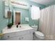 Bathroom with modern sink vanity, and a toilet with a window and shower with a door at 11911 Brownestone View Dr, Charlotte, NC 28269