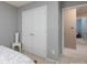This bedroom features a double door closet, pale grey walls, and a small chair at 11911 Brownestone View Dr, Charlotte, NC 28269