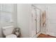Bathroom featuring a white toilet, shower, and wood-look flooring for a modern and clean appearance at 120 Parson Ln, Statesville, NC 28625