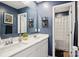 Bright bathroom featuring a double sink vanity, decorative shelving, and a shower with a white curtain at 120 Parson Ln, Statesville, NC 28625