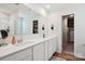 Bathroom with dual sinks, white cabinets and large mirror, plus a walk-in closet at 120 Parson Ln, Statesville, NC 28625