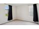Neutral bedroom with large windows, light carpet, and modern black curtains at 120 Parson Ln, Statesville, NC 28625