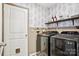 Laundry room with modern washer and dryer with shelving and decorative wallpaper at 120 Parson Ln, Statesville, NC 28625