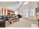 Spacious living room featuring vaulted ceilings, large windows, and a cozy fireplace, seamlessly flowing into an adjacent kitchen at 125 Highland Forest Dr, Clover, SC 29710