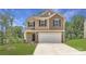Inviting two-story home with attached two-car garage, manicured lawn, and a classic facade at 136 Dorian Pl, Troutman, NC 28166