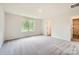 Bright main bedroom featuring plush carpet, a large window, and a conveniently located en-suite bathroom at 136 Dorian Pl, Troutman, NC 28166