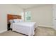 Simple bedroom with natural light and clean white bedding on a carpeted floor at 139 Suggs Mill Dr, Mooresville, NC 28115