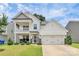 Inviting two-story home with a charming front porch and a two-car garage, complemented by a green lawn at 139 Suggs Mill Dr, Mooresville, NC 28115