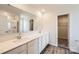 Bathroom with dual sinks, a large mirror, a glass enclosed shower and access to walk in closet at 140 Astor St, Troutman, NC 28166