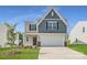 Charming two-story home boasts a classic design, complemented by a well-manicured lawn and a two-car garage at 140 Astor St, Troutman, NC 28166