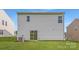 A lovely backyard view of the home's exterior, featuring a sliding glass door and well-maintained green lawn at 144 Astor St, Troutman, NC 28166