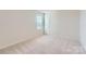 Bright bedroom featuring neutral carpeting, a window for natural light, and fresh, neutral paint at 144 Astor St, Troutman, NC 28166