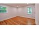 Bright bedroom with hardwood floors, neutral walls, and natural light from two windows at 1513 Greenview Pl, Charlotte, NC 28208