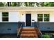 Inviting front entrance featuring a sleek black door, updated fixtures, and brick stairs at 1513 Greenview Pl, Charlotte, NC 28208
