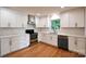 Modern kitchen with white cabinetry, stainless steel appliances, and hardwood floors at 1513 Greenview Pl, Charlotte, NC 28208