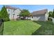 Charming backyard featuring a well-maintained lawn, patio seating area, and mature landscaping with a detached garage at 17327 Summers Walk Blvd, Davidson, NC 28036