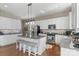Spacious kitchen with white cabinets, stainless appliances, and a large island with bar stool seating at 17327 Summers Walk Blvd, Davidson, NC 28036