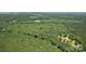 Scenic aerial view of wooded acreage with a peek of the roofline of a house at 1870 Hwy 49 None, New London, NC 28127