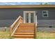 Stairs lead up to a charming back porch with double doors and stylish lighting at 1870 Hwy 49 None, New London, NC 28127
