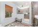 Bright bathroom with gray tiled shower, wood cabinets, light marble countertops and flooring, and a window at 1870 Hwy 49 None, New London, NC 28127