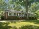 Inviting single-story brick home with white-trimmed windows and a lush, green front yard under the shade of mature trees at 2120 Marwood Ln, Albemarle, NC 28001