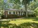 Charming single-story brick home with white shutters and a well-manicured lawn, surrounded by mature trees at 2120 Marwood Ln, Albemarle, NC 28001