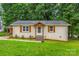 Charming single-story home with a well-manicured lawn and a welcoming front entrance with decorative wood at 21322 Mccall St, Cornelius, NC 28031