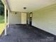 View of a carport featuring a door to the side, lighting, and asphalt driveway at 227 James Rd, Taylorsville, NC 28681