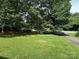 Lush green front yard with trees and partial view of driveway and the home at 227 James Rd, Taylorsville, NC 28681