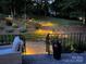 Night view of backyard with illuminated steps, patio furniture, and lush plants at 2317 Houston Branch Rd, Charlotte, NC 28270
