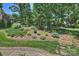 Serene backyard showcasing beautiful landscaping, mature trees, and stone steps at 2317 Houston Branch Rd, Charlotte, NC 28270