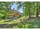 Expansive backyard featuring lush landscaping, a stone patio, and a charming water fountain at 2317 Houston Branch Rd, Charlotte, NC 28270