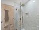 Modern bathroom featuring a glass enclosed shower with gold fixtures and decorative tiles at 2317 Houston Branch Rd, Charlotte, NC 28270