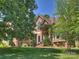 Stately home with a manicured lawn, brick accents, and mature trees framing the facade at 2317 Houston Branch Rd, Charlotte, NC 28270