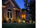 Beautiful exterior home elevation featuring warm lighting, a brick facade, and manicured landscaping at 2317 Houston Branch Rd, Charlotte, NC 28270