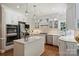 Bright kitchen featuring custom white cabinets, stainless appliances, a center island, and hardwood floors at 2317 Houston Branch Rd, Charlotte, NC 28270