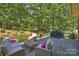 Charming outdoor patio with comfortable seating, lush greenery, and a beautiful backyard view at 2317 Houston Branch Rd, Charlotte, NC 28270