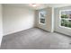Bedroom features neutral carpet, natural light from double windows, with base trim at 2382 Drake Mill Sw Ln, Concord, NC 28025