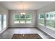 Bright dining area featuring large windows, hardwood floors, a modern chandelier, and french door access at 2382 Drake Mill Sw Ln, Concord, NC 28025