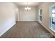 A dining room is illuminated by a modern chandelier and natural light with wood flooring at 2382 Drake Mill Sw Ln, Concord, NC 28025