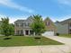 Charming brick two-story home featuring a manicured lawn, inviting front porch, and attached two-car garage at 2382 Drake Mill Sw Ln, Concord, NC 28025