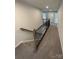 Hallway featuring carpeted steps, and a dark metal banister leading to the second floor at 2382 Drake Mill Sw Ln, Concord, NC 28025