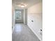 Well-lit laundry room featuring gray tile floors, hanging racks and ample light at 2382 Drake Mill Sw Ln, Concord, NC 28025