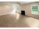 Unfurnished living room with fireplace, hardwood floors, neutral walls, and natural light from double windows at 2382 Drake Mill Sw Ln, Concord, NC 28025