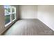 Bright, unfurnished living room featuring wood-look flooring, neutral paint, and large window with backyard view at 2382 Drake Mill Sw Ln, Concord, NC 28025